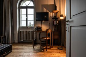 Camera con scrivania, TV e finestra. di One Suite Hotel - Zollhaus a Berna