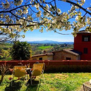 duas cadeiras e uma mesa num quintal com flores em Hotel Santa Caterina em Siena