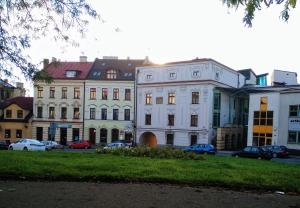 um grupo de edifícios com carros estacionados num parque de estacionamento em Upper Apart em Cieszyn