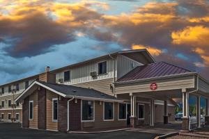 a building in front of a building with a cloudy sky at Super 8 by Wyndham Boise in Boise