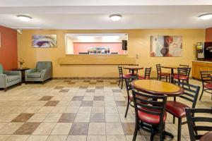 a restaurant with tables and chairs and a bar at Super 8 by Wyndham Albuquerque West/Coors Blvd in Albuquerque