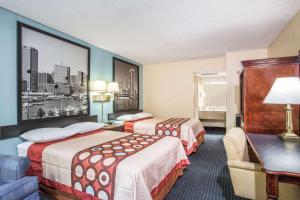 A bed or beds in a room at Super 8 by Wyndham Camp Springs/Andrews AFB DC Area