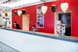 Un homme et une femme assis au comptoir d'un restaurant dans l'établissement Hôtel Sainte-Rose, à Lourdes