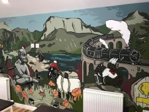 a mural in a room with a train and mountains at Glen Nevis Youth Hostel in Fort William