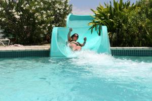 - une femme sur un toboggan aquatique dans une piscine dans l'établissement The Marlin at Taino Beach Resort, à Freeport