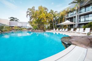 a swimming pool with chairs and a building at The Executive Inn, Newcastle in Newcastle