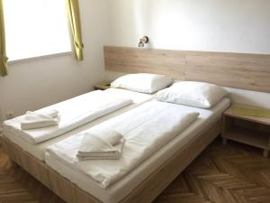 twee bedden met witte kussens in een kamer bij Apartmaji in sobe Tina in Kranjska Gora