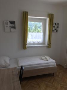 een raam in een kamer met een bed en een tafel bij Apartmaji in sobe Tina in Kranjska Gora