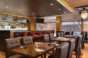 un ristorante con tavoli e sedie e un bar di Coast Edmonton Plaza Hotel by APA a Edmonton