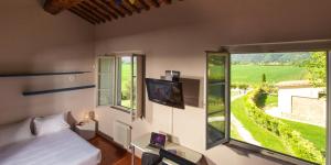 a bedroom with a bed and a large window at Cascina Canova B&B in San Giuliano Terme