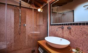 a bathroom with a sink and a glass shower at Cascina Canova B&B in San Giuliano Terme