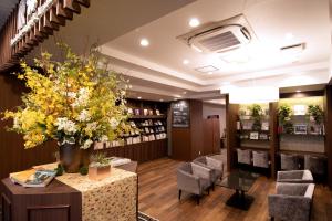 um salão com cadeiras, uma mesa e flores em HOTEL Mai Sakura em Nara