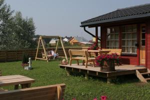 un patio trasero con una mesa de picnic y un parque infantil en Love Island Guesthouse, en Druskininkai