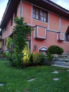 a pink house with a garden in front of it at Once upon a time in Koprivshtitsa