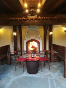 a room with a fireplace with a table and chairs at Once upon a time in Koprivshtitsa