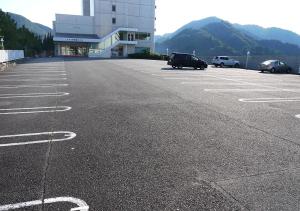 un parking vide avec des voitures garées devant un bâtiment dans l'établissement Nishiizu Matsuzaki Itoen Hotel, à Matsuzaki