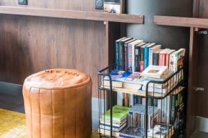 ein Bücherregal mit Büchern neben einem Stuhl in der Unterkunft ibis Marne La Vallée Val d'Europe in Montévrain