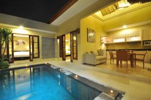 - une piscine dans une maison avec un salon dans l'établissement The Jas Villas, à Seminyak