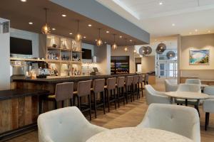 een bar in een restaurant met tafels en stoelen bij Hyatt Place Niagara Falls in Niagara Falls