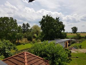 - une vue sur une maison avec un champ et des arbres dans l'établissement Ferienwohnung an der Unditz, à Neuried