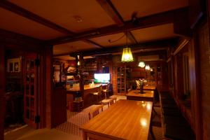 une salle à manger avec une table en bois et une télévision dans l'établissement Lake village donaludo Pension, à Kitashiobara