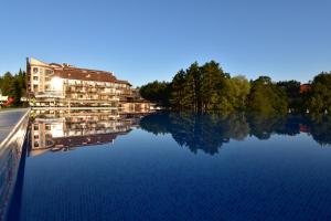 Reflexion eines Gebäudes im Wasser in der Unterkunft SPA Hotel Infinity Park Velingrad in Welingrad