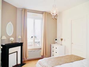 - une chambre avec un lit, une fenêtre et un lustre dans l'établissement La Bulle de Champagne, à Épernay