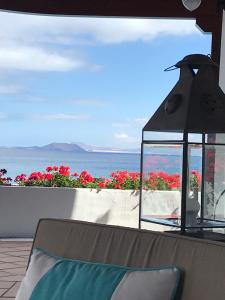 een patio met een lantaarn en uitzicht op de oceaan bij Hotel Casa Del Embajador in Playa Blanca