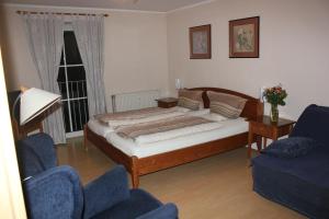 a bedroom with a bed and two chairs and a window at Ferienwohnungen Goldbach 1. Stock in Regensburg