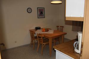 a kitchen with a table with chairs and a clock on the wall at Ferienwohnungen Goldbach 1. Stock in Regensburg