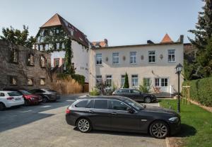 une voiture noire garée dans un parking en face d'un bâtiment dans l'établissement Ferienhaus Marie, à Erfurt