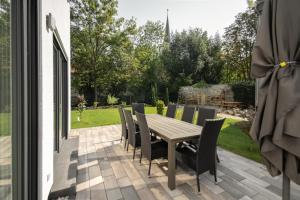 Une table et des chaises en bois sont disponibles sur la terrasse. dans l'établissement Ferienhaus Marie, à Erfurt