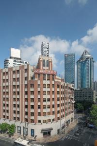 ein großes Gebäude mit einem Schild darauf in einer Stadt in der Unterkunft Golden Tulip Bund New Asia (The Former Jinjiang Metropolo Hotel Classiq Shanghai,Rock Bund) in Shanghai