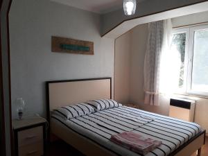 een kleine slaapkamer met een bed en een raam bij Apartment on Guramishvili Street 1 in Tskaltubo