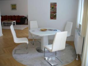 a white dining room with a white table and chairs at Ferienwohnung Riedner in Lüneburg