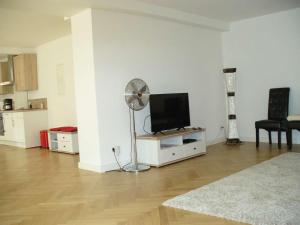 a living room with a fan and a flat screen tv at Ferienwohnung Riedner in Lüneburg