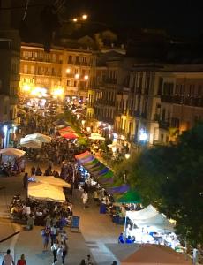 uma multidão de pessoas num mercado ao ar livre à noite em La Casa nel Corso em Cagliari