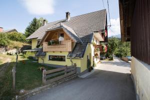 een geel huis met een veranda en een balkon bij Farmhouse pri Miklavu in Bohinj