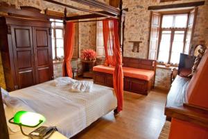 a bedroom with two beds with orange curtains at Archontiko Hatzipanayioti in Leonidion