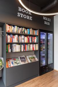 een boekenwinkel met planken gevuld met boeken bij Jet Hotel Zurich Airport in Rümlang