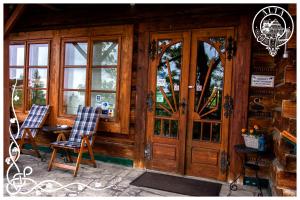 une cabine en bois avec deux chaises et une porte dans l'établissement Willa Alta, à Bukowina Tatrzańska