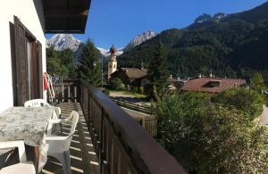 un balcone di una casa con tavolo e sedie di Appartamento Piè a Canazei