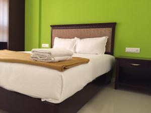 Una cama o camas en una habitación de Temple Plaza Kochi