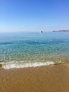 - un bateau dans l'océan avec une plage de sable dans l'établissement Seafront, à Karistos