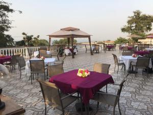 d'une terrasse avec des tables et des chaises et un chiffon de table violet. dans l'établissement Hotel Cabenda, à Freetown