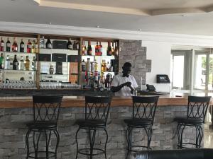 un homme debout au bar d'un restaurant dans l'établissement Hotel Cabenda, à Freetown