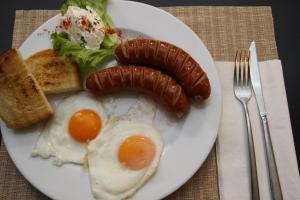 een bord ontbijtproducten met eieren, worst en toast bij Domin Osijek in Osijek