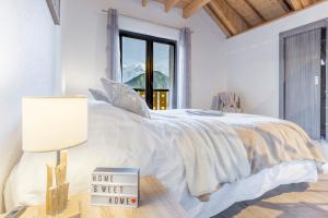 Un dormitorio blanco con una cama con un cartel. en Les Edelweiss Mont-Blanc - Gîte Classé 3 Etoiles, en Passy