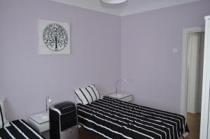 a bedroom with a bed with a black and white blanket at A Casa do Mestre in Évora