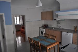 a kitchen with a table and a sink and a stove at A Casa do Mestre in Évora